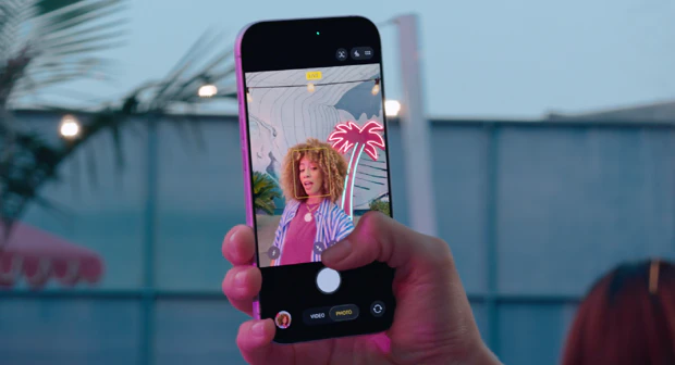 Smartphone i hånden med fokus på skærmen, sammenlign mobilabonnementer