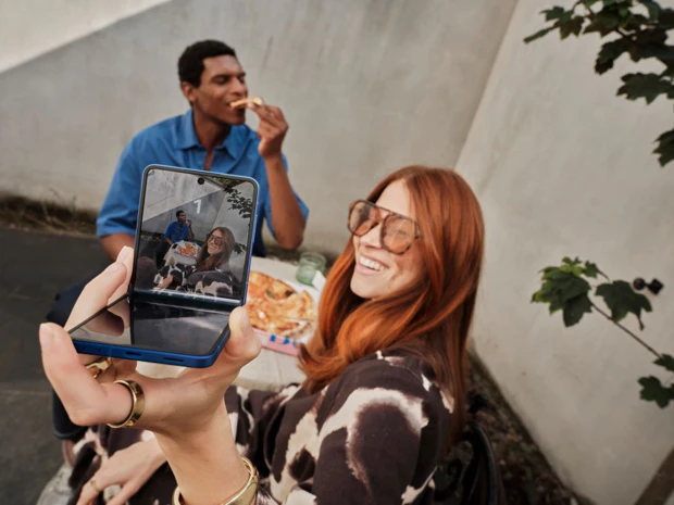 Person optager video på Samsung Galaxy flipphone med 5G-abonnement