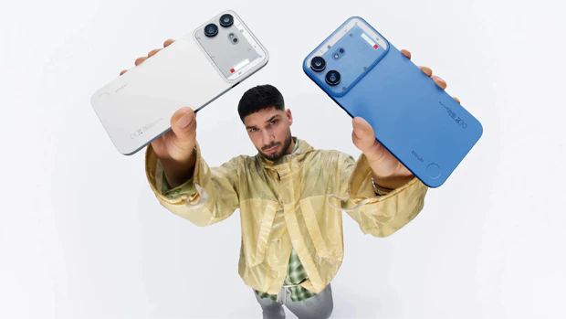 Witte en blauwe versie van de Nothing Phone (4b) in de lucht omhooggehouden door een man Witte en blauwe versie van de Nothing Phone (4b) in de lucht omhooggehouden door een man