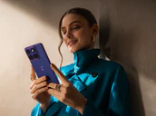 Woman holding motorola edge 70 fusion in pantone orient blue