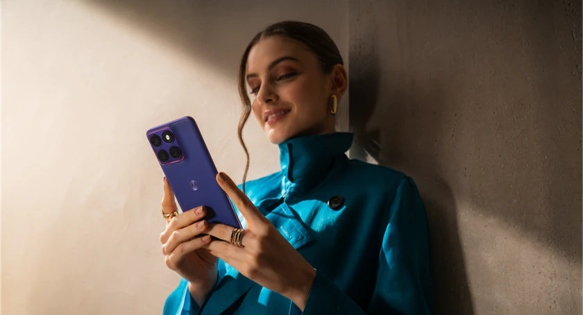 Woman holding motorola edge 70 fusion in pantone orient blue