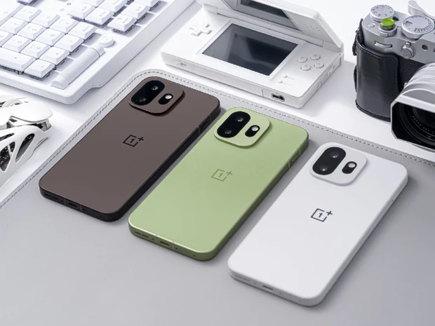 Tres dispositivos OnePlus 15T uno al lado del otro; foco en la parte trasera de fibra de vidrio mate en marrón Pure Cocoa, verde Relaxing Matcha y blanco Healing White Chocolate
