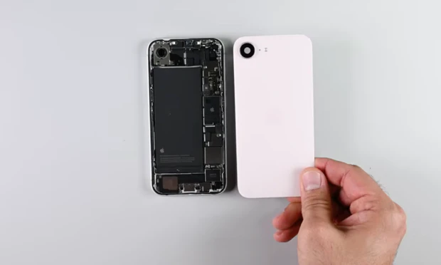 Binnenkant van geopende iPhone 16e naast de roze backpanel van de iPhone 17e